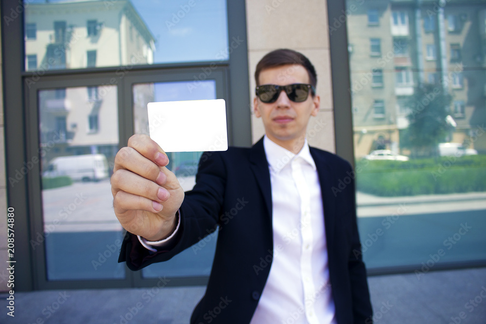 a man is holding a business card in front of him Copyspace a man is holding a business card in front of him Copyspace