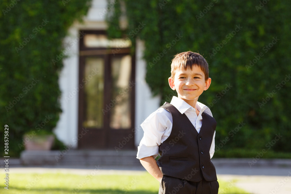 Cheerful boy in fashionable suit on green grass Cheerful boy in fashionable suit on green grass