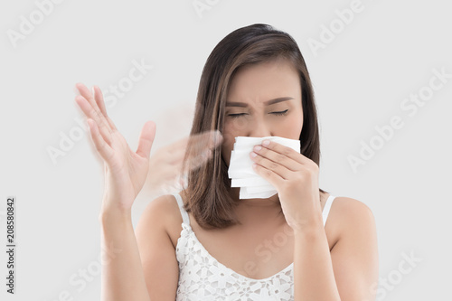 The woman holds tissue cover her nose because she smell bad.