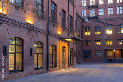 Night view. Modern Loft-style offices located in the old factory building. Red brick houses. Vintage. Buildings with large Windows