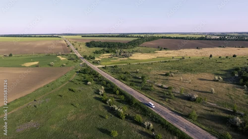 flight over the fields and the old road with the traveling cars at sunset. flight over the fields and the old road with the traveling cars at sunset.