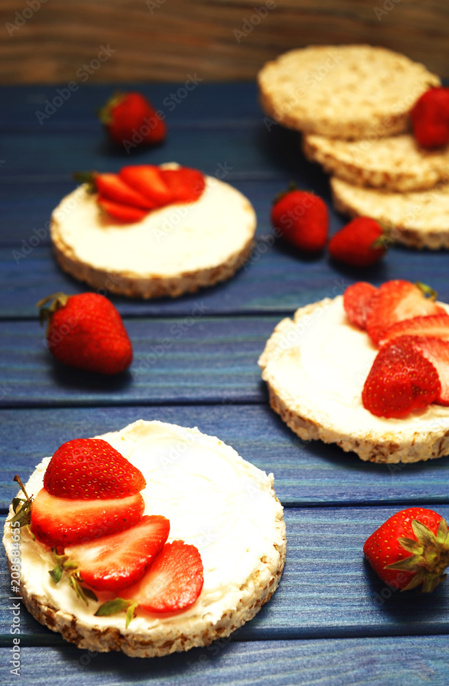 healthy Breakfast and a snack of rice bread with red strawberries, with cheese on a blue wooden background healthy Breakfast and a snack of rice bread with red strawberries, with cheese on a blue wooden background