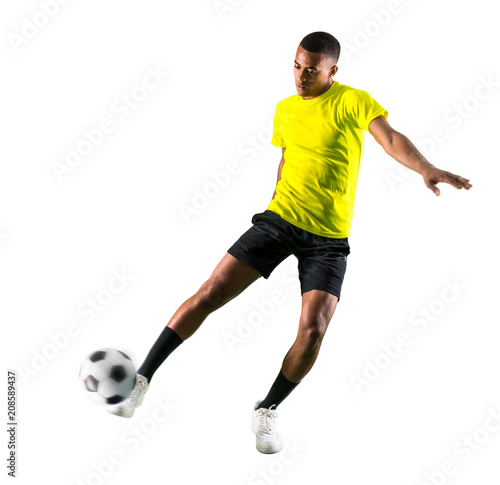 Soccer player man with dark skinned playing kicking the ball © luismolinero