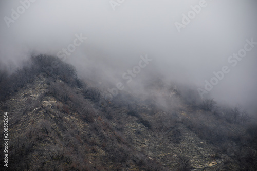 Panorama of the foggy winter landscape in the mountains with snow and rocks, Azerbaijan, Lahic, Big Caucasus