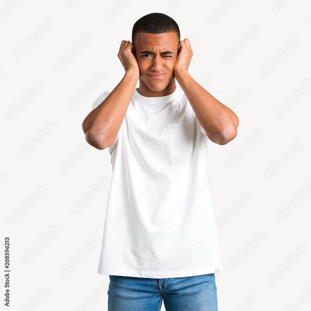 Young african american man covering both ears with hands. Frustrated expression on isolated background Young african american man covering both ears with hands. Frustrated expression on isolated background