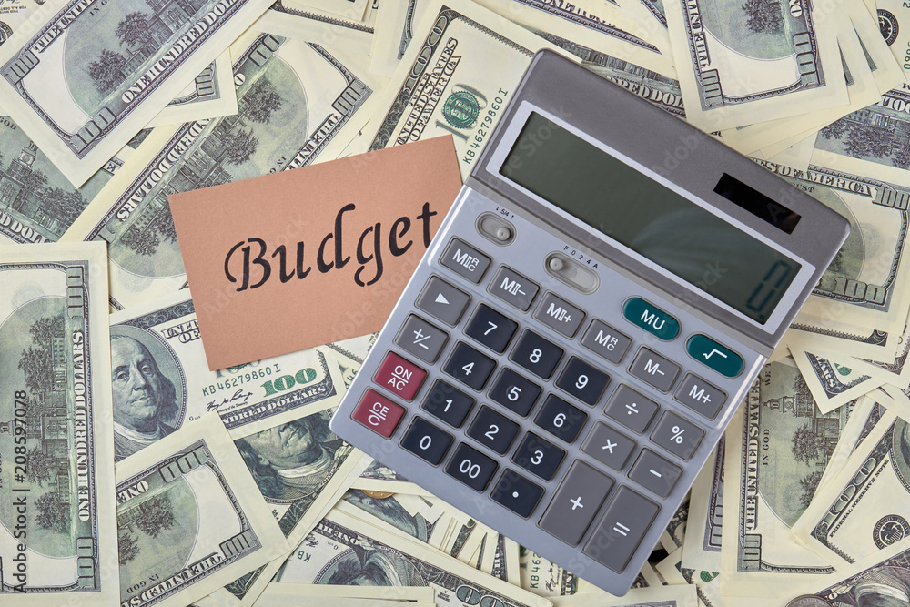 Calculator and pile of money dollars. Budget and account concept. Calculator and pile of money dollars. Budget and account concept.