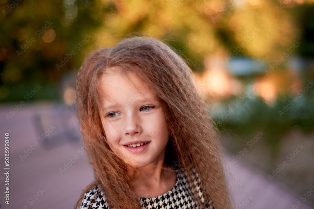 The baby is 4 years old, with blue eyes and small curls. Children's enjoyment of life and adventures. Warm Golden sunset light.Smiles The baby is 4 years old, with blue eyes and small curls. Children's enjoyment of life and adventures. Warm Golden sunset light.Smiles