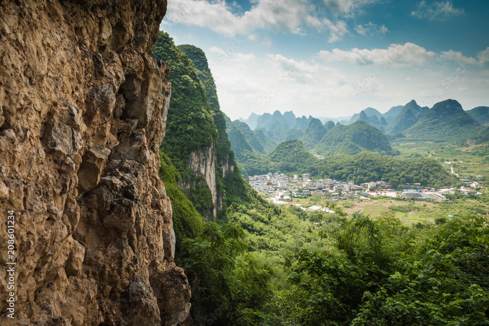 Fototapeta premium Scenic summer sunny landscape at Yangshuo County of Guilin, China. View of beautiful karst mountains and the Li River (Lijiang River) with azure water. Amazing green hills on blue sky background.
