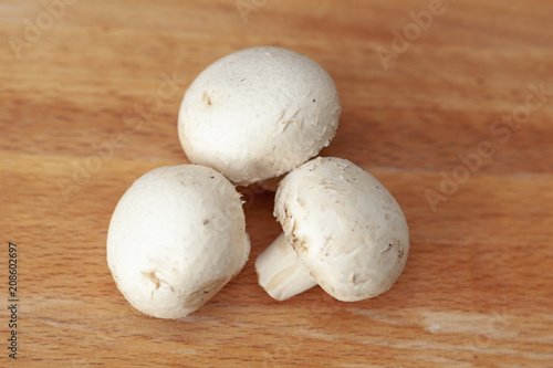 Fresh raw brown chestnut mushrooms on wooden background - top view