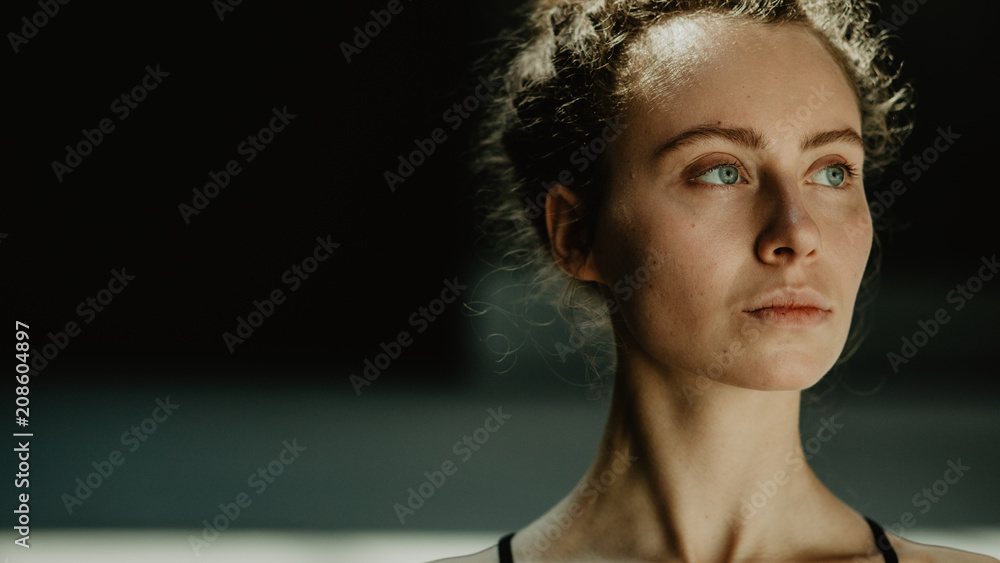 Portrait of young beautiful strong and self confident female feminist with serious face on the dark background with copy space. Portrait of young beautiful strong and self confident female feminist with serious face on the dark background with copy space.