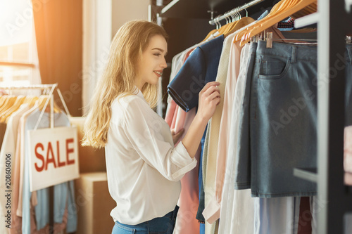 Smiling girl bying clothes in showroom photo