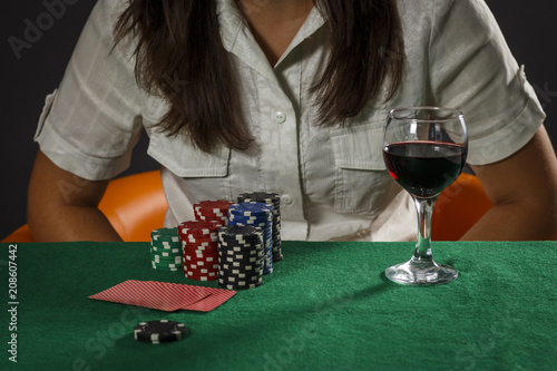 Young girl with a glass of wine playing poker