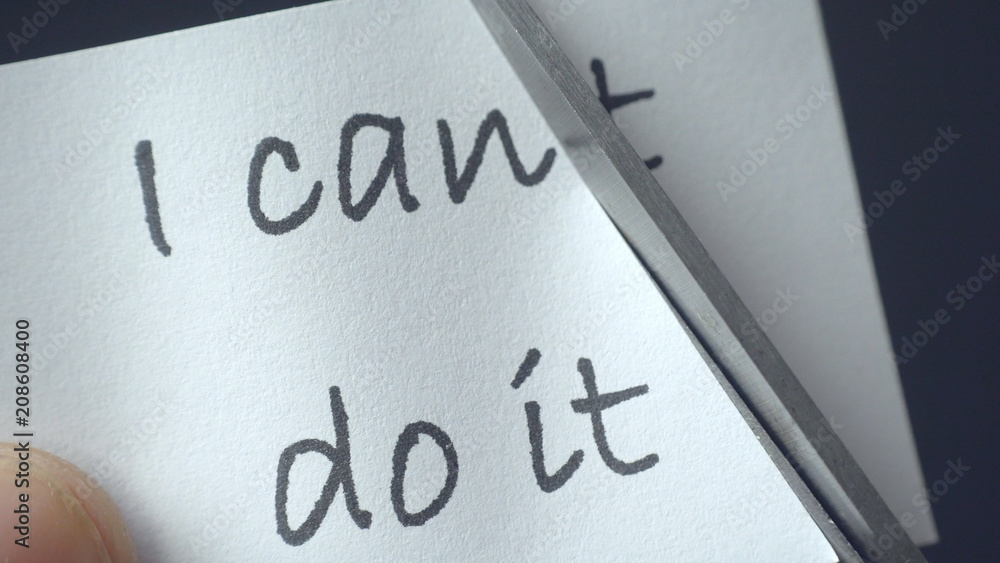 Man using scissors to remove the word can't to read I can do it concept for self belief Man using scissors to remove the word can't to read I can do it concept for self belief