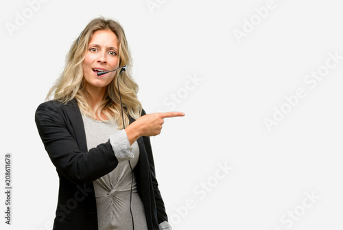 Young woman operator from call center pointing away side with finger