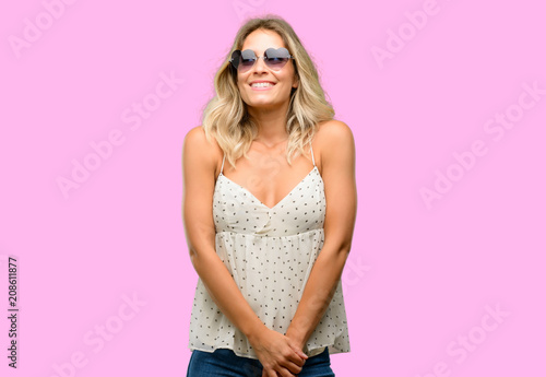 Young woman wearing sunglasses with heart shape thinking and looking up expressing doubt and wonder