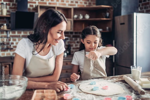 mother and daughter preparing dough for cookies