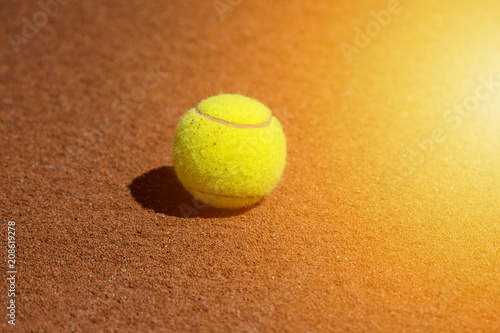 Yellow tennis ball on a clay court.