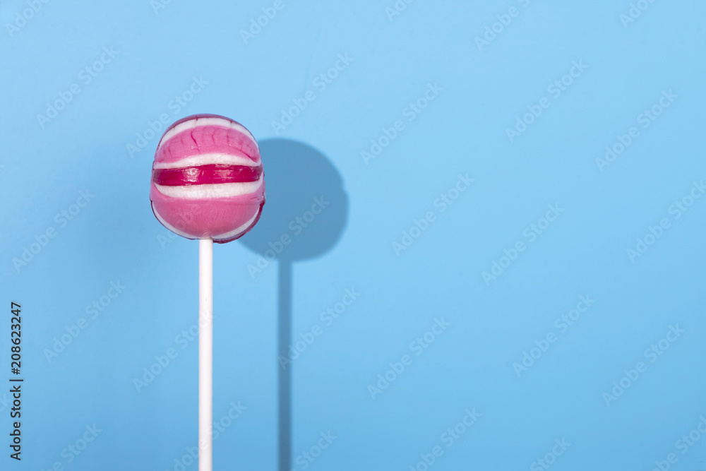 Pink Lolipop candy with shadow on pastel blue background Pink Lolipop candy with shadow on pastel blue background