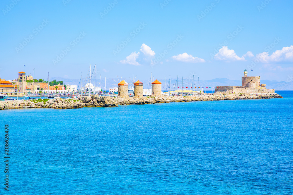Medieval Agios Nikolaos Fortress and old windmills at Mandraki harbour in Rhodes Town, Mediterranean Sea, Rhodes Island, Greece