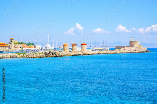 Fototapeta Naklejka Na Ścianę i Meble -  Medieval Agios Nikolaos Fortress and old windmills at Mandraki harbour in Rhodes Town, Mediterranean Sea, Rhodes Island, Greece
