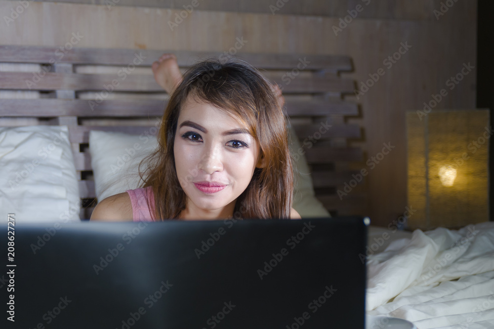 beautiful and happy student woman enjoying on bed with laptop computer watching internet movie or having video chat call with friend at night beautiful and happy student woman enjoying on bed with laptop computer watching internet movie or having video chat call with friend at night