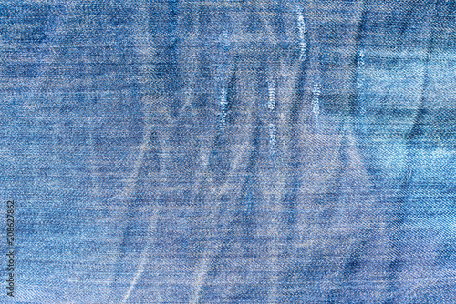 Texture of a fabric of a blue piece of jeans trousers