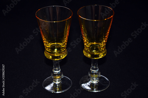 glasses of whiskey wine vodka transparent yellow stack on black background