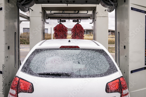 Coche lavándose en túnel de lavado de un lavadero de coches