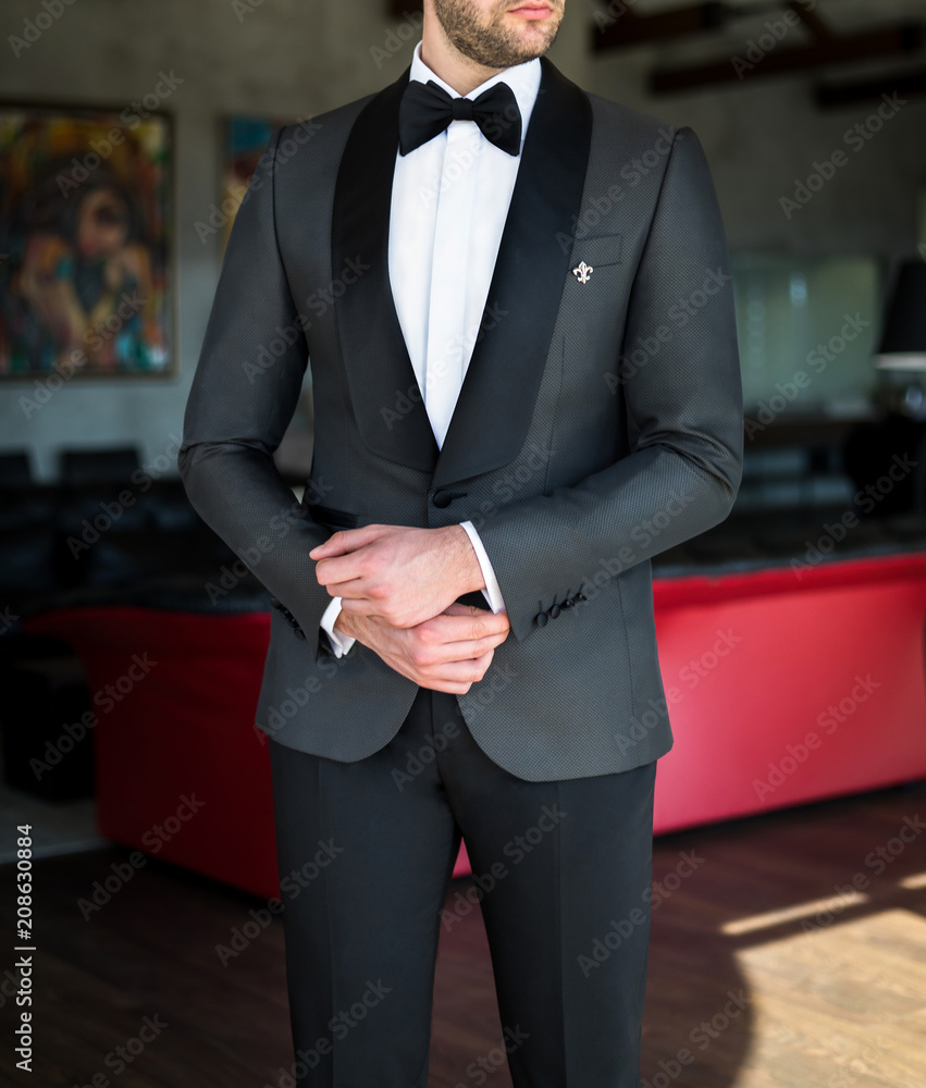 Man in expensive custom tailored tuxedo suit posing indoors Stock