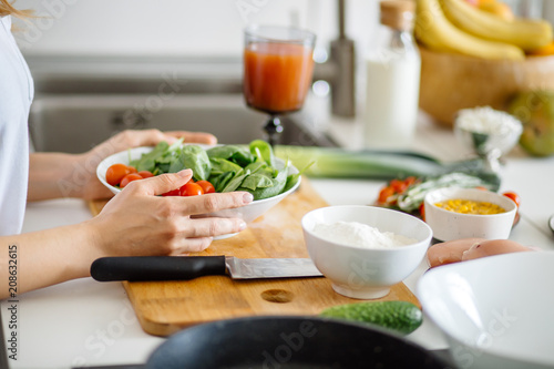 Fresh organicvegetables on white desk background on cutting board. Healthy natural food on rustic wood. Tomato, lettuce, carrot, pepper, zucchini and other cooking ingredients top view photo