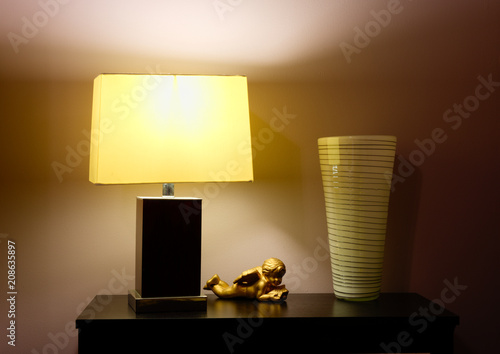 desk with a lamp, statue and a vase