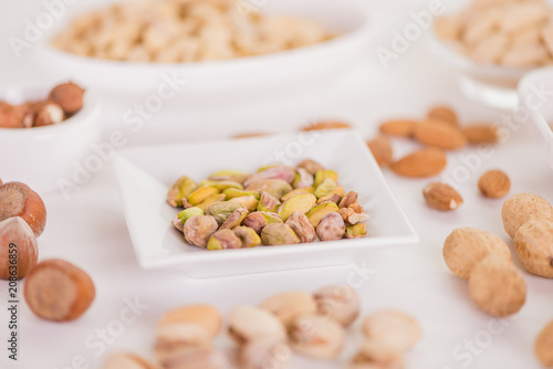 healthy snack selection of various nuts on white wood background