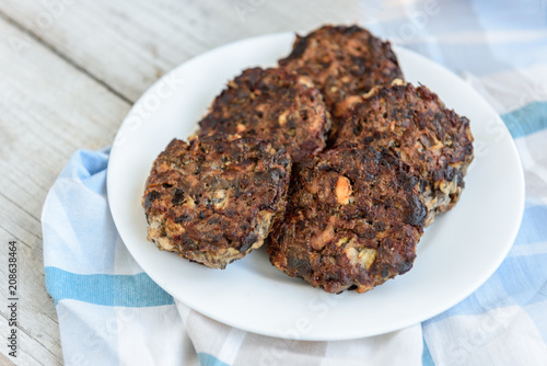 Homemade mushroom cutlets with rice porridge on wooden background. Healthy food for lunch or dinner.