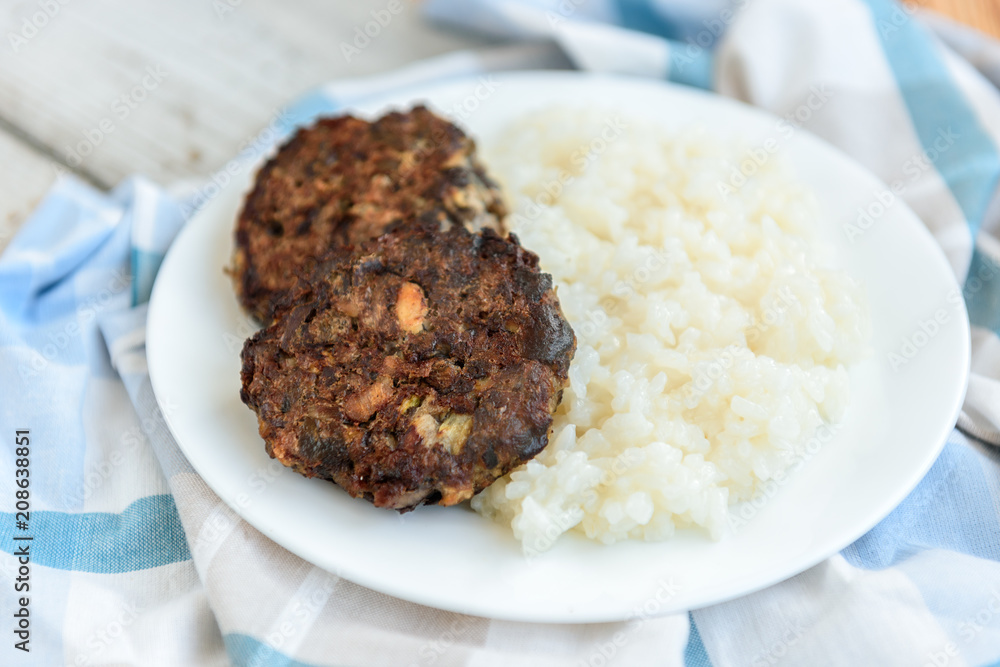 Homemade mushroom cutlets with rice porridge on wooden background. Healthy food for lunch or dinner. Homemade mushroom cutlets with rice porridge on wooden background. Healthy food for lunch or dinner.