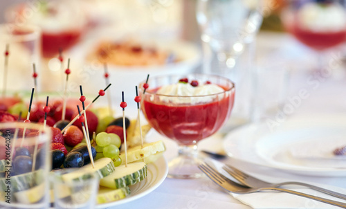 Close-up image of a festive table with sliced fruits and desserts.