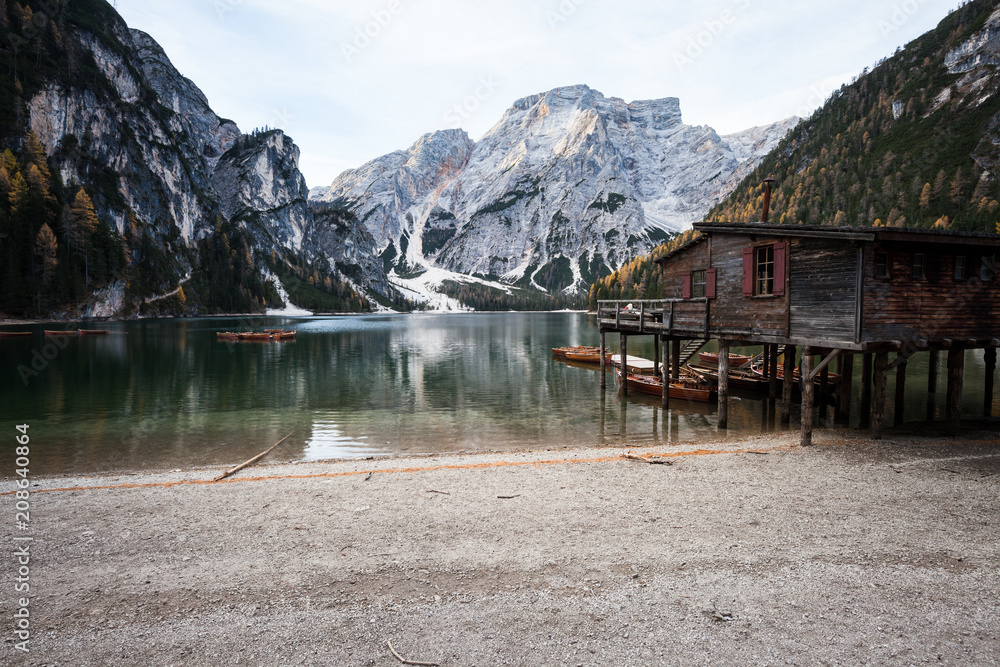Boats and old house at the alpine mountain lake. Lago di Braies, Dolomites Alps, Italy