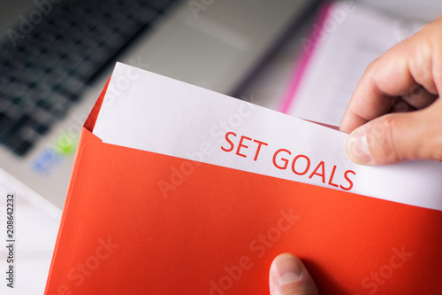 A man opens a red letter Set Goal