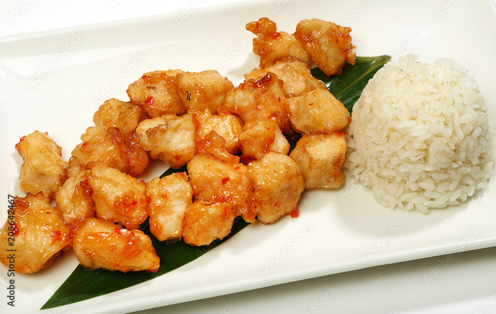 Chicken in a spicy-sweet sauce-fried chicken in tempura, with Sriracha sauce, with a side dish of rice Chicken in a spicy-sweet sauce-fried chicken in tempura, with Sriracha sauce, with a side dish of rice