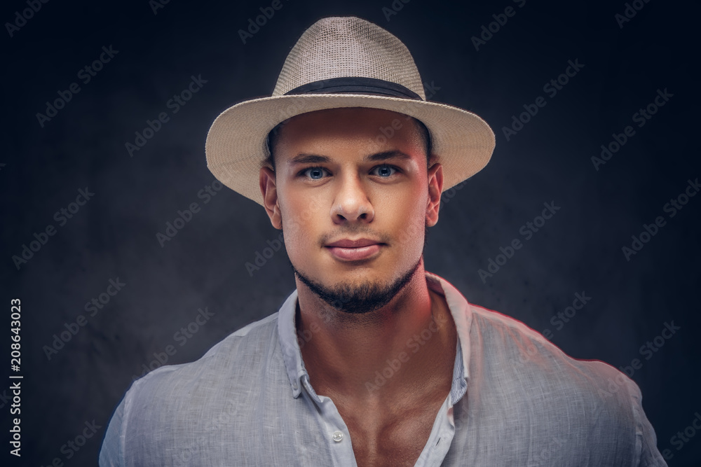 Close-up portrait of a handsome fashionable bearded man in a white shirt and panama hat. Close-up portrait of a handsome fashionable bearded man in a white shirt and panama hat.
