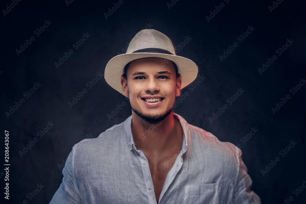 Close-up portrait of a smiling handsome fashionable bearded man in a white shirt and panama hat. Close-up portrait of a smiling handsome fashionable bearded man in a white shirt and panama hat.