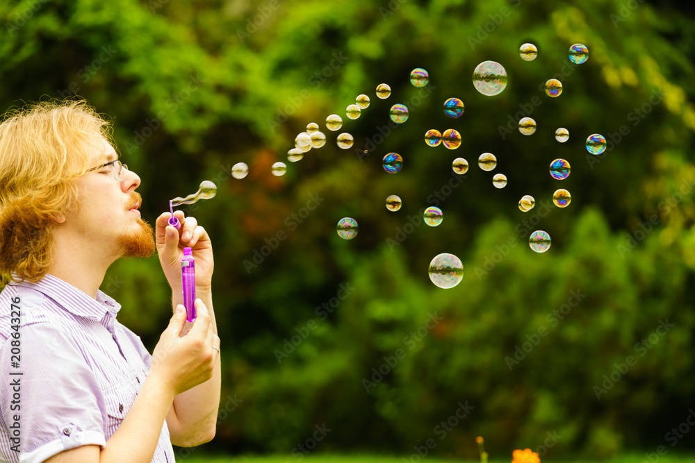 Man blowing soap bubbles outdoor Man blowing soap bubbles outdoor