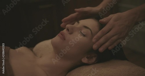 Young woman relaxing with reiki treatment at healtcare spa photo