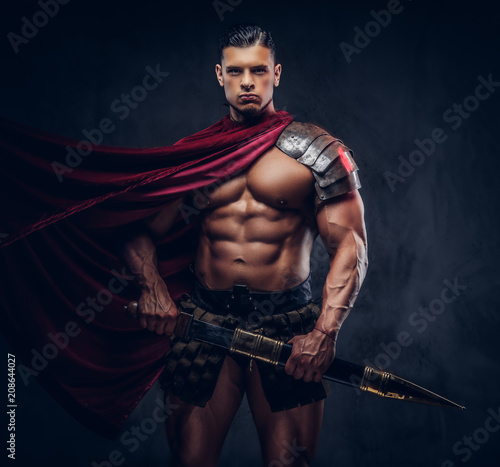 Fototapeta Naklejka Na Ścianę i Meble -  Brutal ancient Greece warrior with a muscular body in battle uniforms