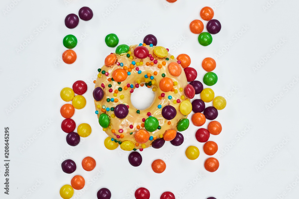 Appetizing golden donut sprinkled with colorful chocolate pellets. Appetizing golden donut sprinkled with colorful chocolate pellets.
