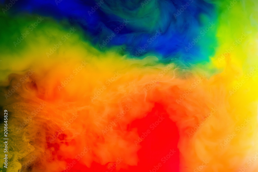 ink in the water.Splash of red, blue, yellow and green paint. Abstract background