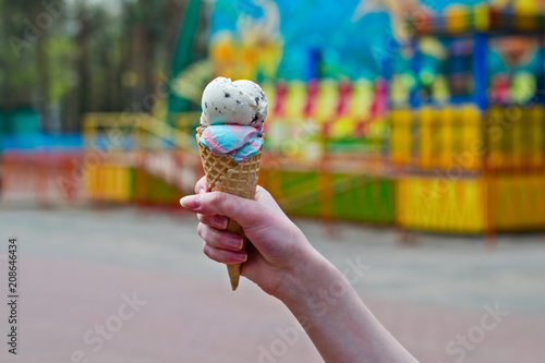 Hand of a girl with an ice cream in an amusement park