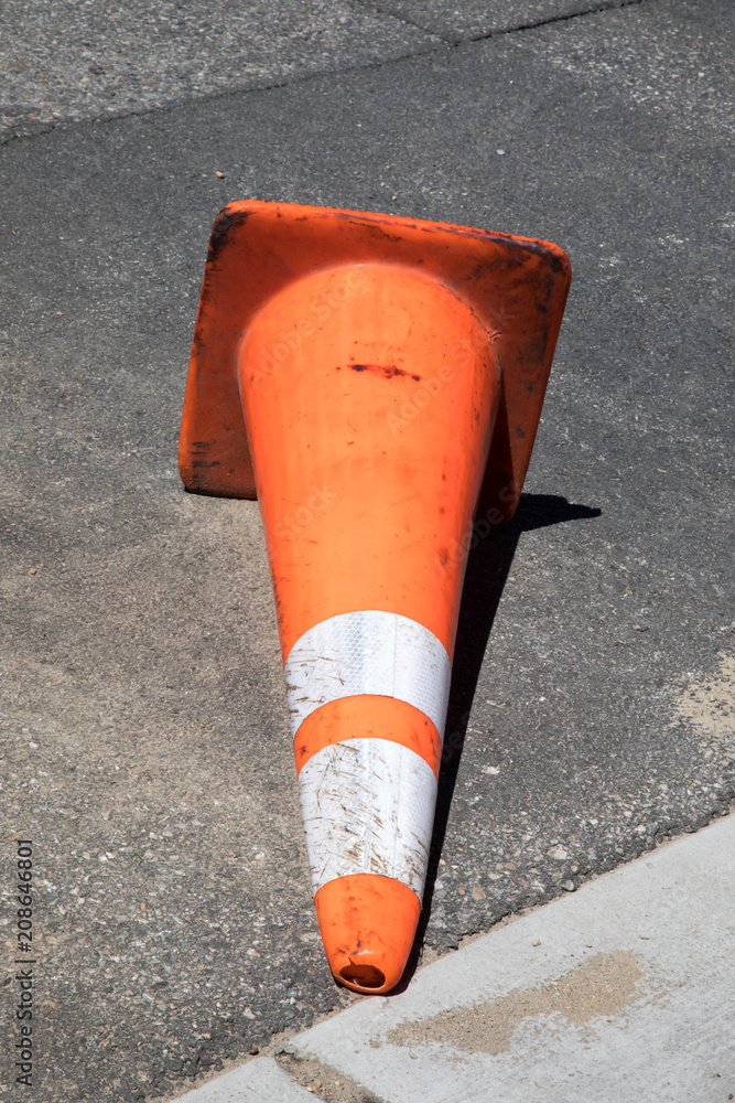 Tipped over traffic cone during road construction Photos | Adobe Stock