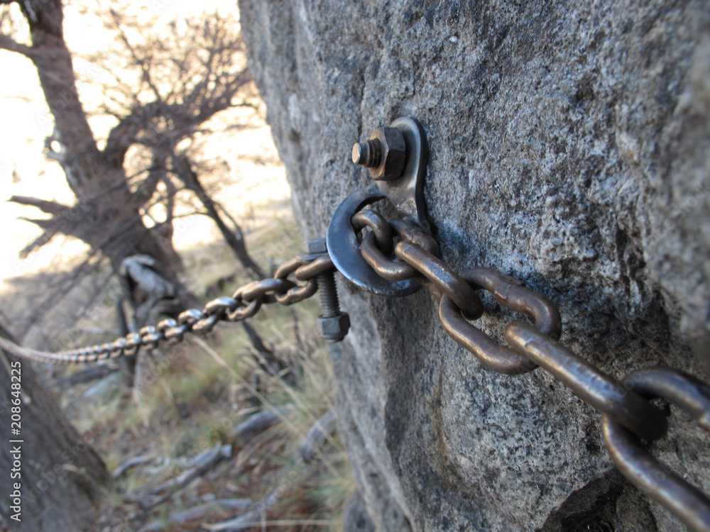 A steel chain is anchored in a rock and used as handrail A steel chain is anchored in a rock and used as handrail