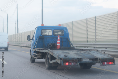 Tow truck on the highway with metal safety barrier and acoustic wall