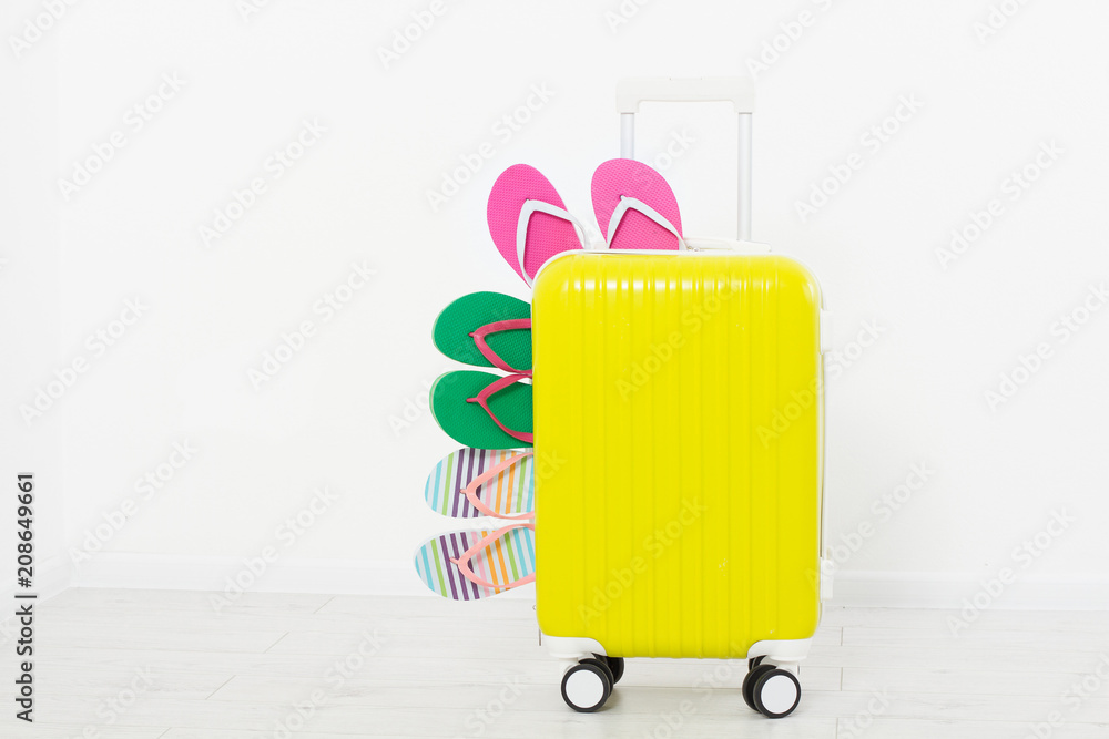 Yellow suitcase isolated on white background Summer holidays. summer flip flops or slippers.Sandals beach.Travel valise or bag. Mock up. Copy space. Template. Blank. Yellow suitcase isolated on white background Summer holidays. summer flip flops or slippers.Sandals beach.Travel valise or bag. Mock up. Copy space. Template. Blank.